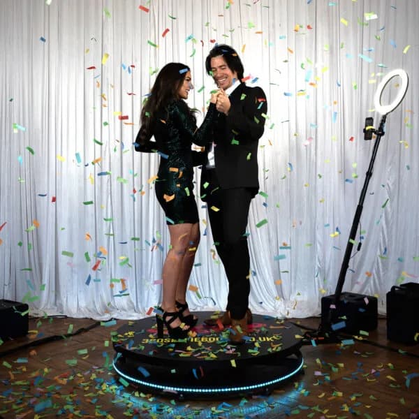 Couple celebrating with confetti on a 360 photo booth platform