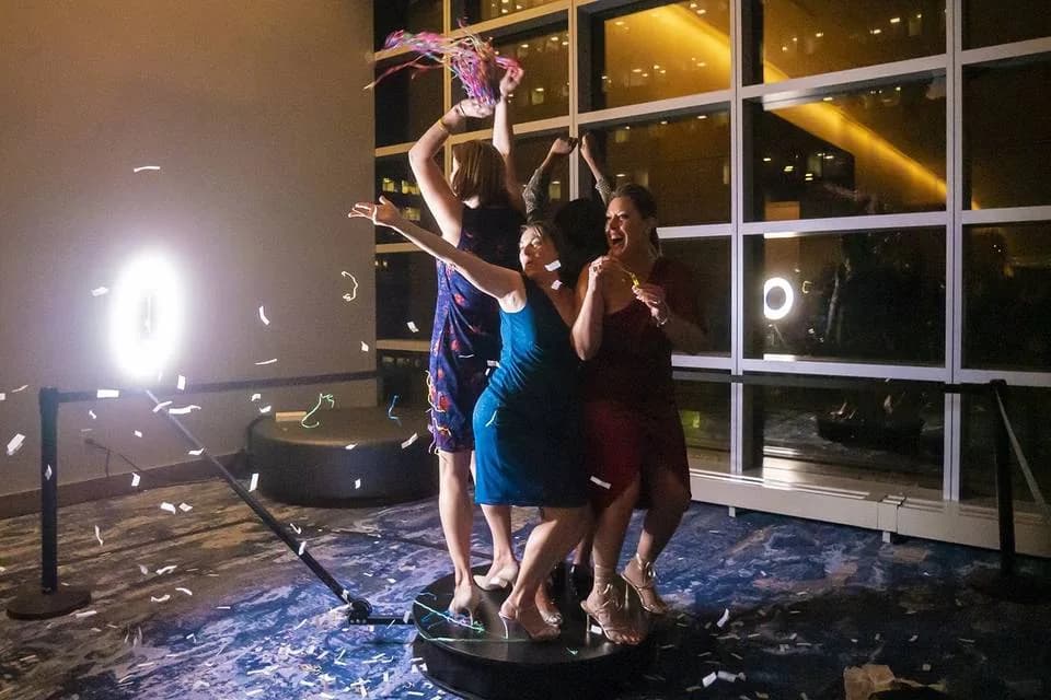 Group of guests celebrating together on a 360 photo booth platform