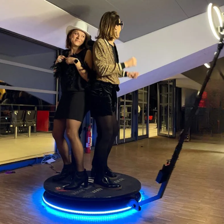 Two guests posing together on a 360 photo booth platform