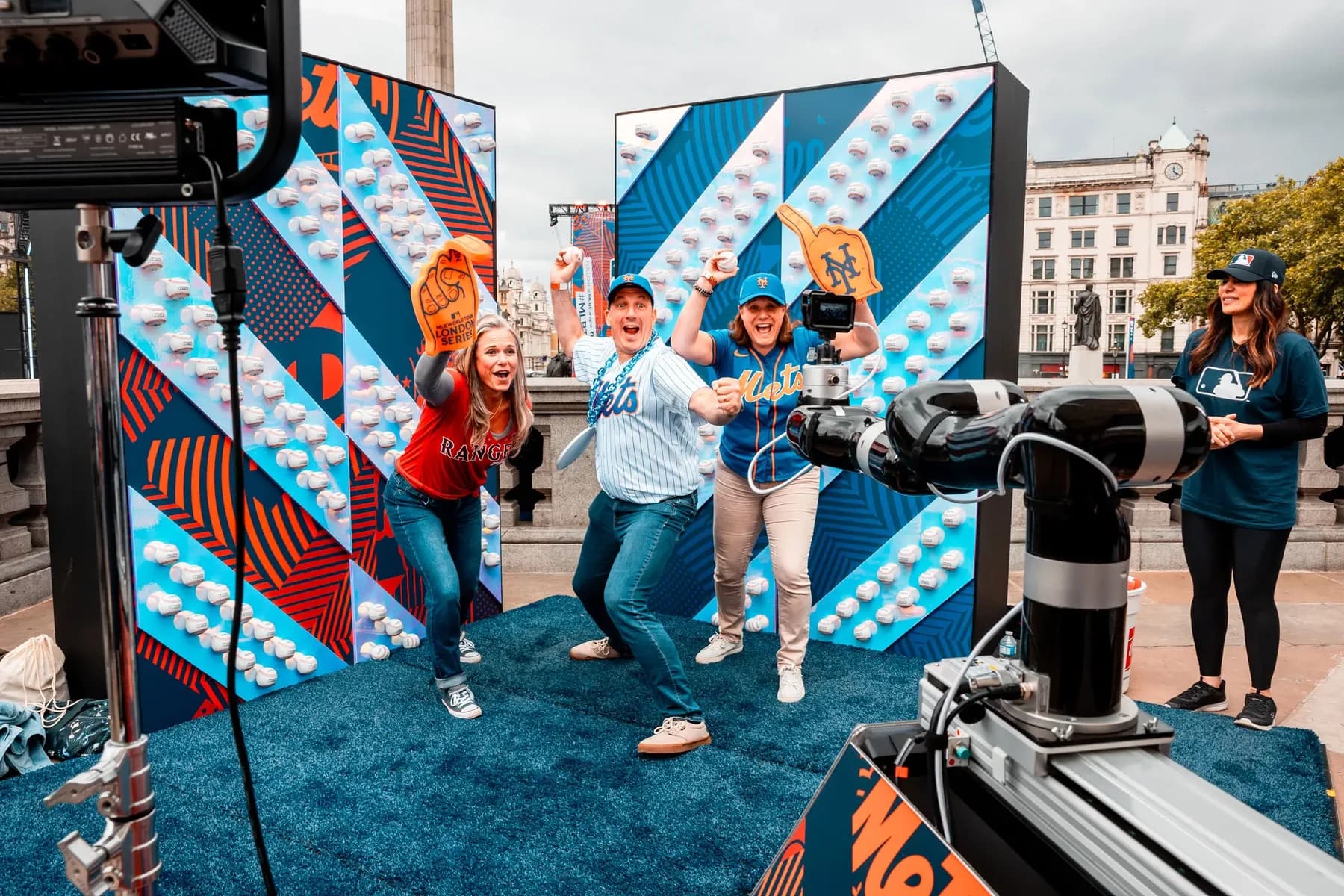 Guests posing for the Glambot in front of a gold backdrop