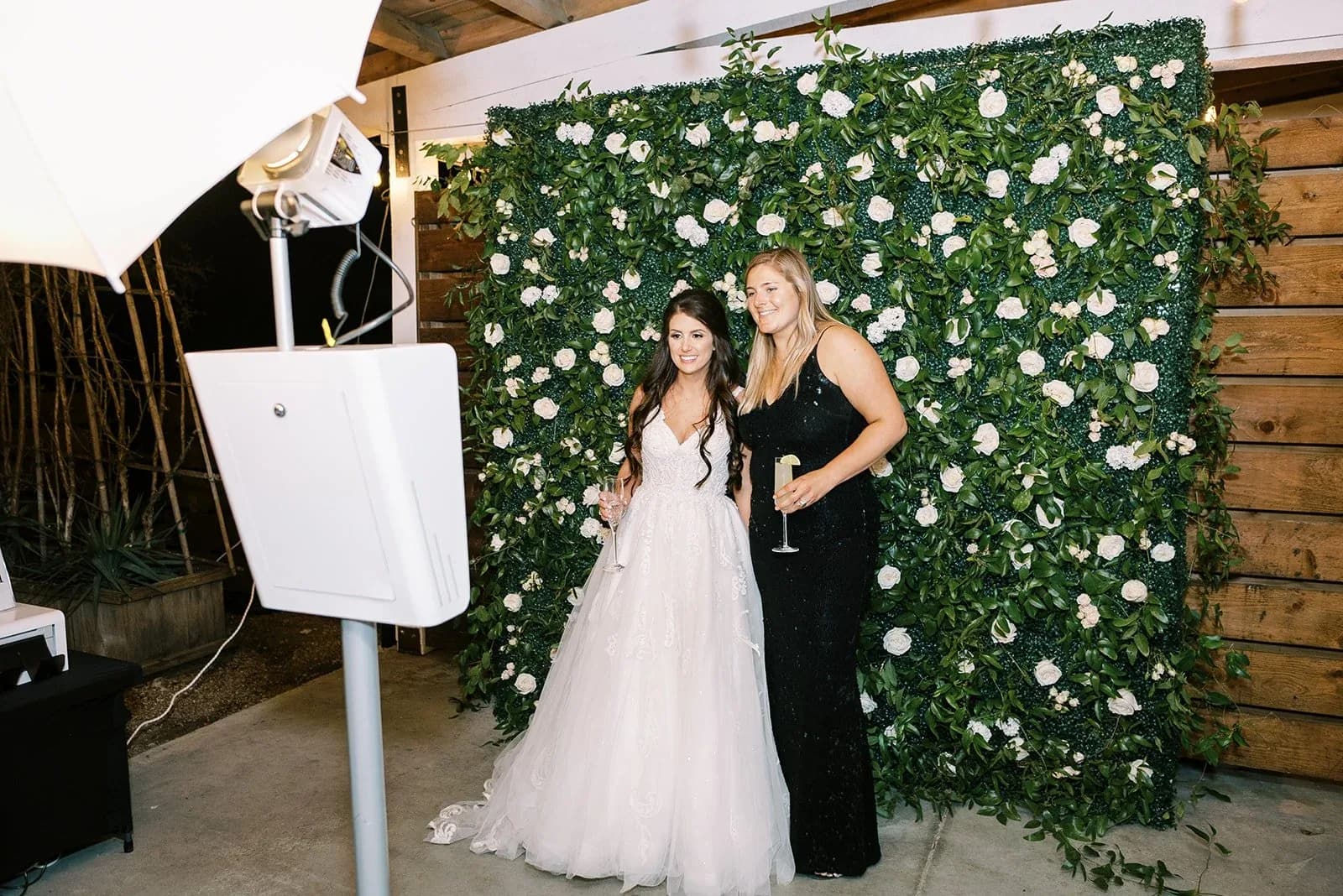 Bride photographed at a Chicago wedding photo booth in front of a white flower wall